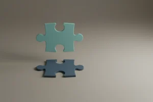 Two puzzle pieces poised to interlock on a soft gray background, symbolizing refined feedback and clearer communication.