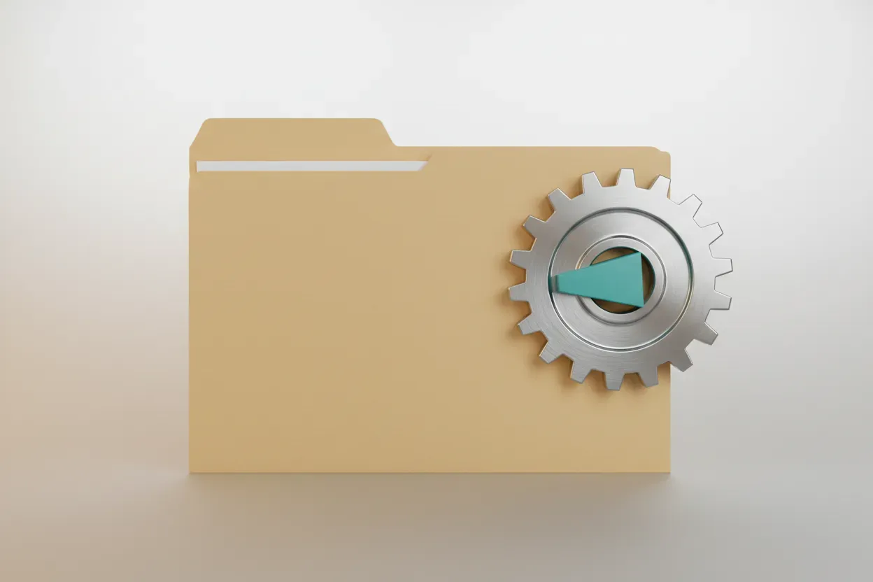 Manila folder against a silver gear with a small teal block jamming the teeth on a soft neutral background.